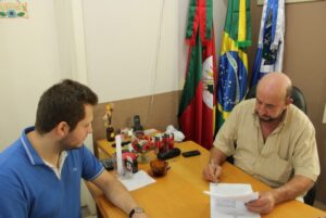 Secretário de Planejamento Vitor Kroth e Prefeito Hélio de Queiroz em ato de assinatura do convênio.